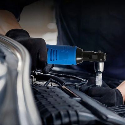 Une clé à cliquet douille électrique sans fil bleu dans la main d'un homme qui répare une voiture