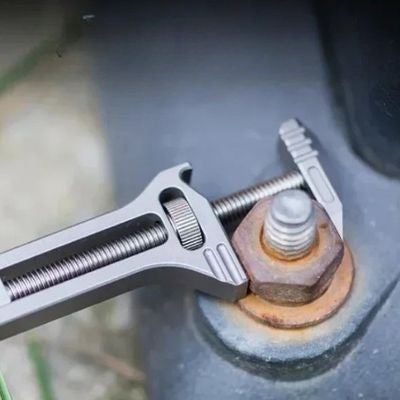 Clé anglaise mini de poche sur un boulon rouillé