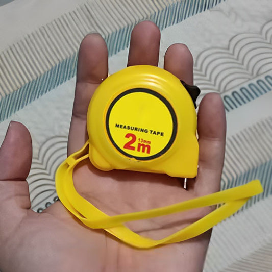 Mètre ruban jaune main