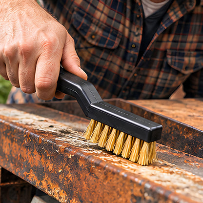 Une brosse métallique en fil de laiton, faisant partie d'un lot de 10 pièces, dans la main d'un homme qui enlève la rouille sur l'acier d'une poutre