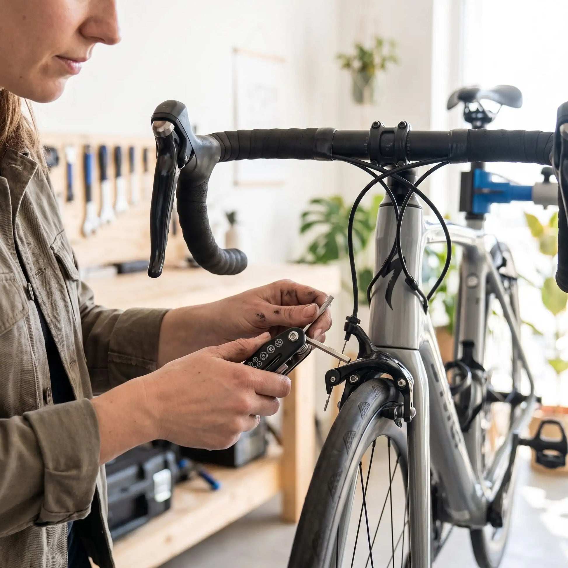 Clé Allen mini outil 16 en 1 dans la main d'une femme qui répare les freins de son vélo 