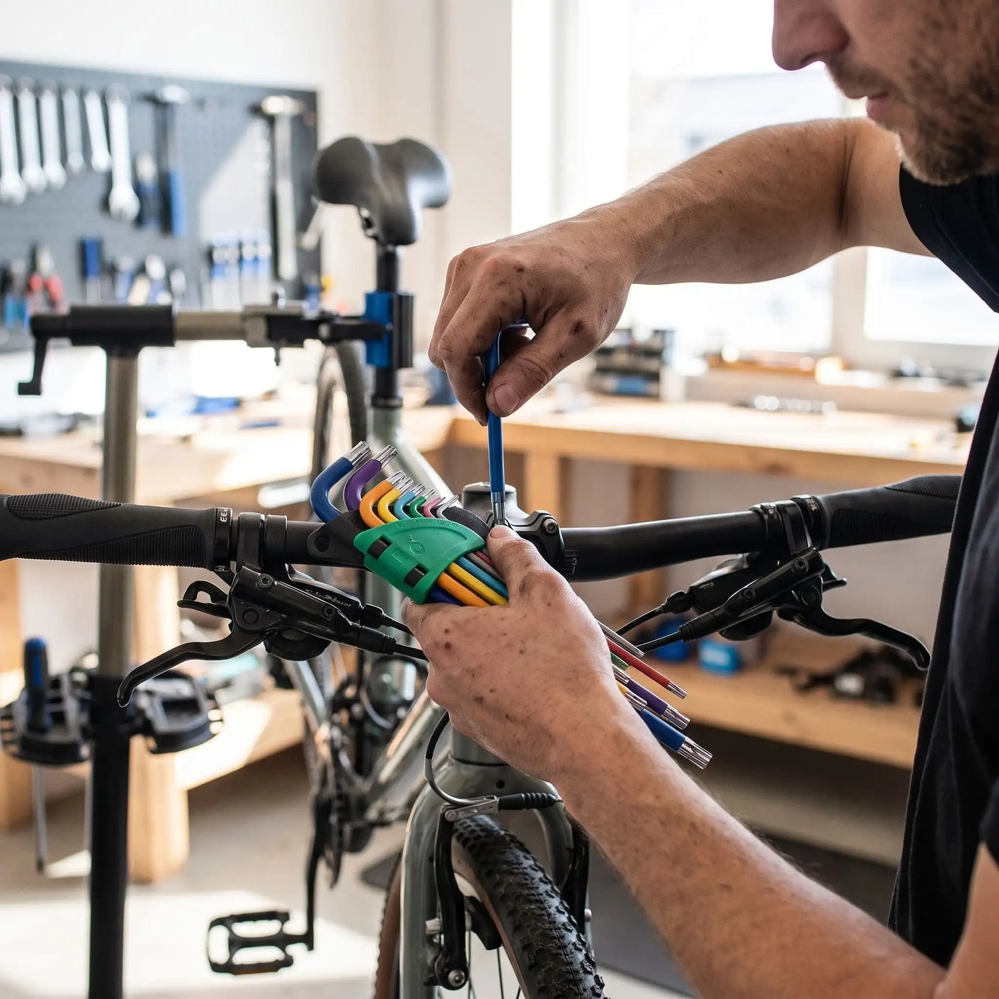 cle-torx-jeu-de-9-cles-de-couleurs-t10-a-t50-en-l-dans la main d'un homme qui répare son vélo
