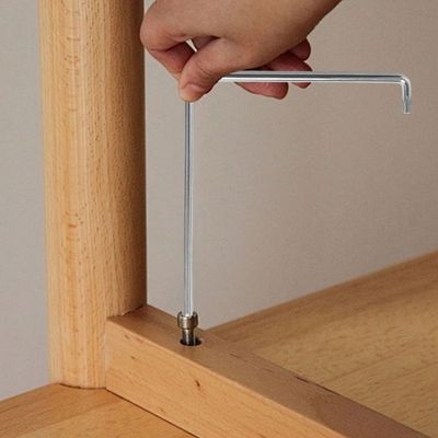 Clé torx Réglage fenêtre TX15 & Allen 4mm dans la main d'une femme qui visse une patte de table