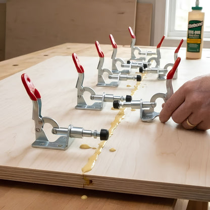Trois serre-joints action au-dessus de la colle sur une table de bois
